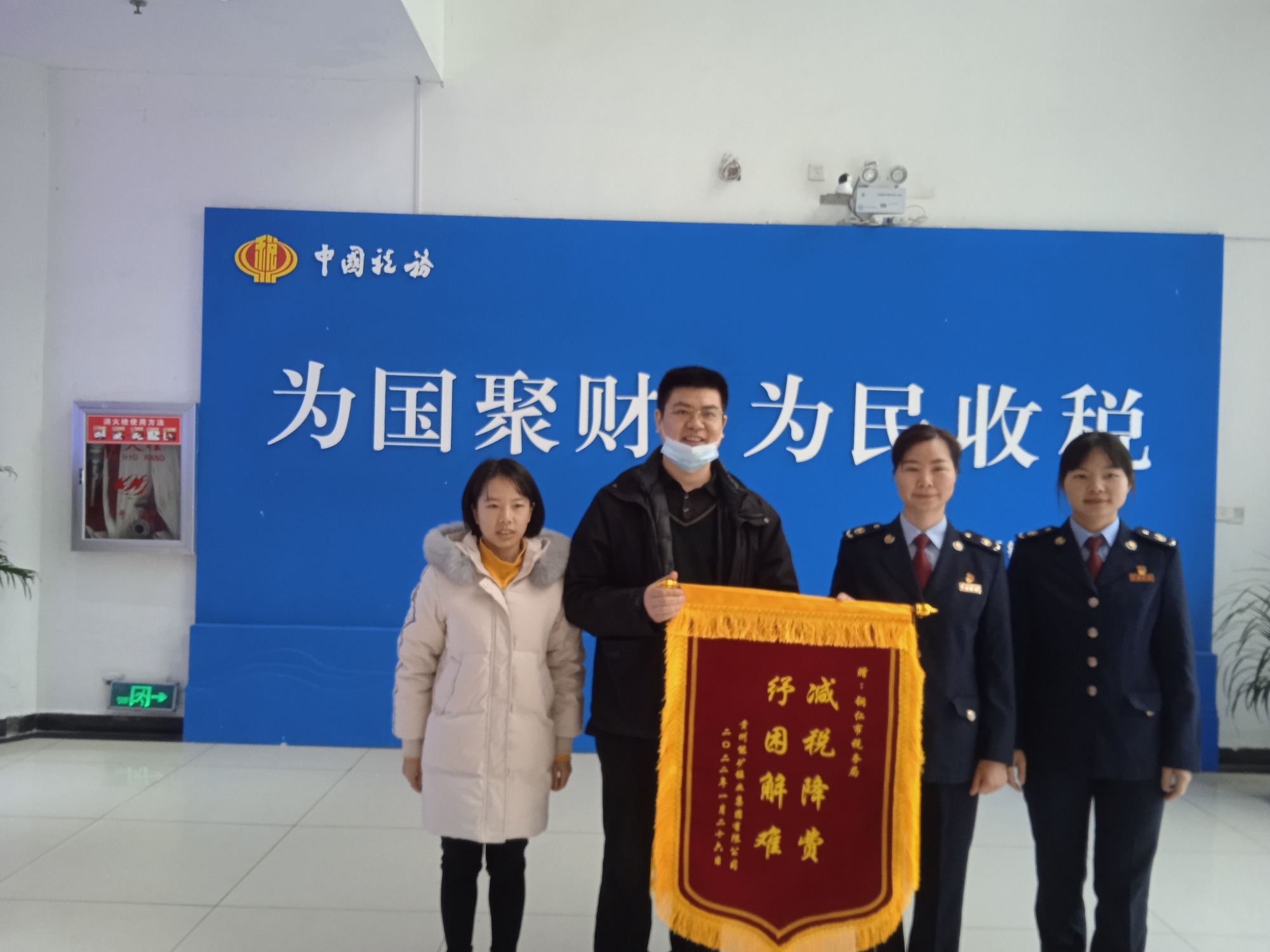 能礦錳業(yè)黨委委員、財務(wù)總監(jiān)張華超代表公司向銅仁市稅務(wù)機關(guān)贈送錦旗.jpg